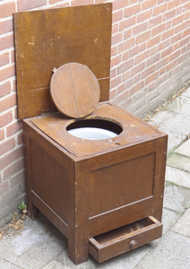 878245 Afbeelding van een houten 'kamergemak' ('droogplee') met daarin een wit geëmailleerde emmer en onderin een ...